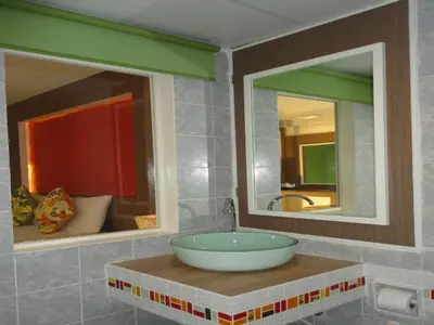 a bathroom with a bowl sink and two mirrors at La Moon At Phuket - SHA Extra Plus in Phuket Town