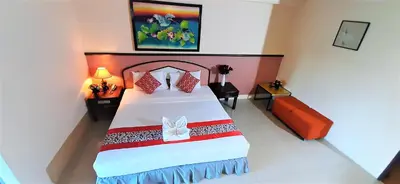 a bedroom with a large bed with red and white pillows at La Moon At Phuket - SHA Extra Plus in Phuket Town