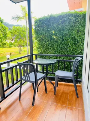 a balcony with two chairs and a table and a table at Koh Yao Modern Inn -SHA Plus in Ko Yao Yai