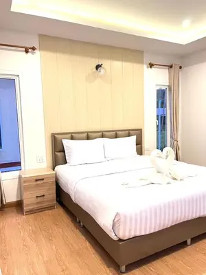 a bedroom with a large bed with white sheets at Koh Yao Modern Inn -SHA Plus in Ko Yao Yai