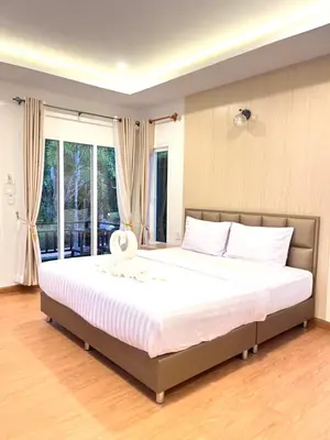 a bedroom with a large bed with white sheets at Koh Yao Modern Inn -SHA Plus in Ko Yao Yai