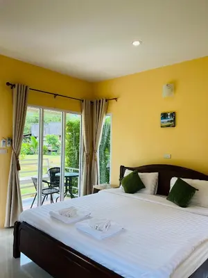 a bedroom with a large bed and a balcony at Koh Yao Modern Inn -SHA Plus in Ko Yao Yai