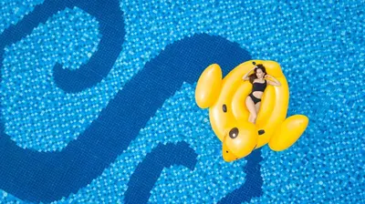 a woman is riding on a yellow raft in a pool at The Senses Resort & Pool Villas, PHUKET in Patong Beach