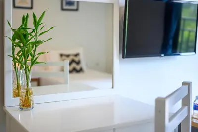 a vase sitting on a table with a plant in it at Maikhao Hotel, Phuket in Mai Khao Beach