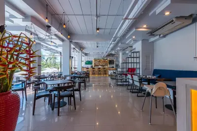 a restaurant with tables and chairs in a room at Maikhao Hotel, Phuket in Mai Khao Beach