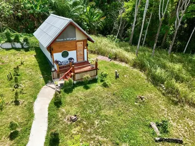 a small house on a grassy hill with a pathway at Resting Place Ko Yao Yai in Ko Yao Yai