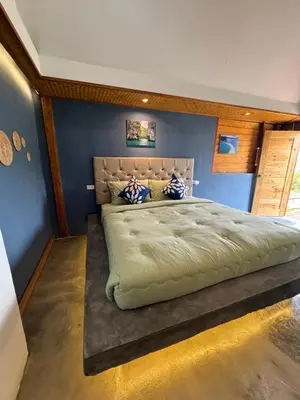 a large bed in a bedroom with a blue wall at Resting Place Ko Yao Yai in Ko Yao Yai
