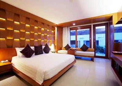 a bedroom with a large white bed and a window at La Flora Resort Patong in Patong Beach