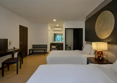 a hotel room with two beds and a desk at Nai Yang Beach Resort and Spa in Nai Yang Beach