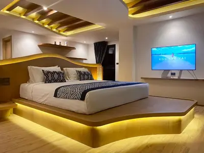 a bedroom with a large bed and a flat screen tv at Baan Taranya Koh Yao Yai Resort in Ko Yao Yai