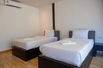 two beds in a room with white sheets at Ibiza House Phi Phi in Phi Phi Don