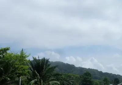 a view of a mountain with palm trees and clouds at Majestic Villas Guesthouse Phuket. in Rawai Beach
