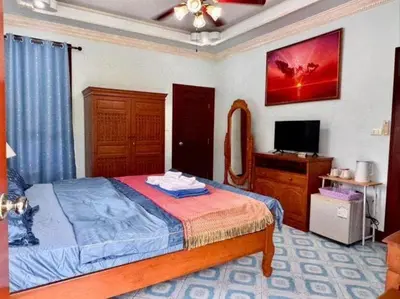 a bedroom with a bed and a television in it at Majestic Villas Guesthouse Phuket. in Rawai Beach