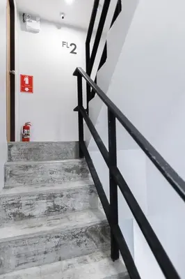 a staircase in a house with a black railing at Minimal House Patong in Patong Beach