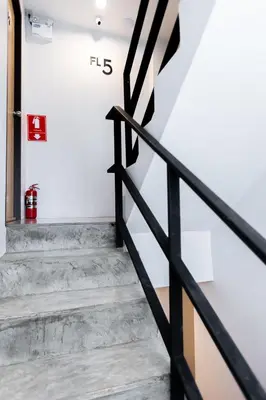 a staircase in a house with a black railing at Minimal House Patong in Patong Beach