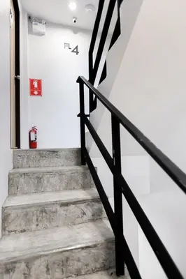 a staircase in a house with a black railing at Minimal House Patong in Patong Beach