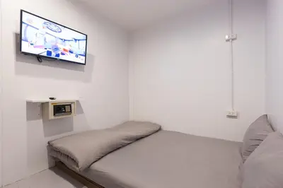 a bedroom with a bed and a tv on the wall at Minimal House Patong in Patong Beach
