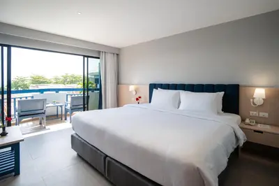 a bedroom with a large white bed and a balcony at Phuket Island View Resort - SHA Extra Plus in Karon Beach
