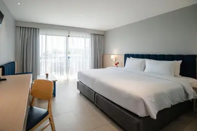 a bedroom with a large bed and a large window at Phuket Island View Resort - SHA Extra Plus in Karon Beach