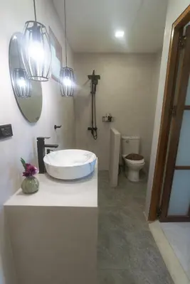 a bathroom with a sink and a toilet and a mirror at Palm Garden Resort in Rawai Beach