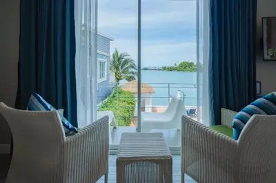 a room with chairs and a view of the ocean at Phuket Boat Quay Hotel Panwa Beach in Panwa Beach