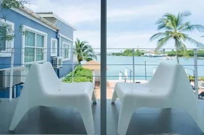 two white chairs on a balcony with a view of the water at Phuket Boat Quay Hotel Panwa Beach in Panwa Beach