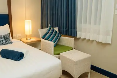 a hotel room with a bed and a chair at Phuket Boat Quay Hotel Panwa Beach in Panwa Beach