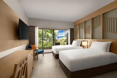 a hotel room with two beds and a television at Courtyard by Marriott Phuket, Patong Beach Resort in Patong Beach