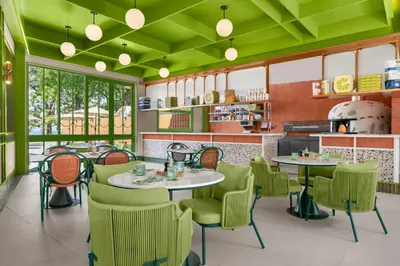 a restaurant with green ceilings and tables and chairs at Courtyard by Marriott Phuket, Patong Beach Resort in Patong Beach