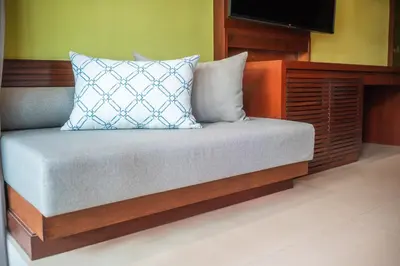 a bed with a pillow and a tv on top at Courtyard by Marriott Phuket, Patong Beach Resort in Patong Beach