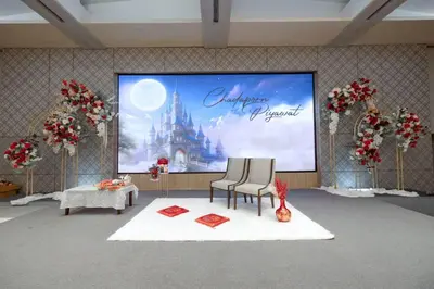 a stage with two chairs in front of a large screen at Phuket Merlin Hotel in Phuket Town