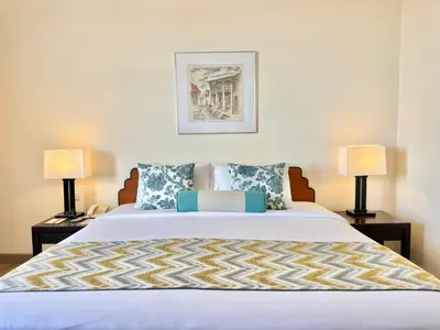 a bedroom with a large bed with two lamps at Phuket Merlin Hotel in Phuket Town