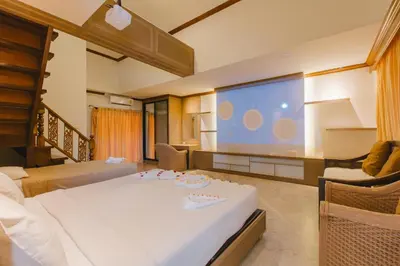 a living room with a large screen and a bed at Royal Prince Residence, Patong Beach in Patong Beach