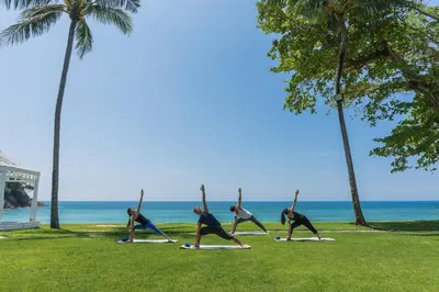 a group of people doing yoga on the beach at Phuket Marriott Resort & Spa, Merlin Beach in Patong Beach