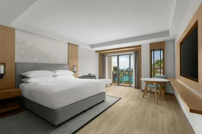 a bedroom with a large white bed and a table at Phuket Marriott Resort & Spa, Merlin Beach in Patong Beach