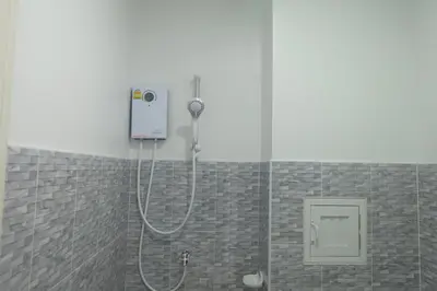 a shower with a shower head in a bathroom at Airport Pearl Residence in Nai Yang Beach