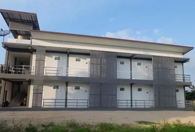 a large building with white doors and a balcony at Airport Pearl Residence in Nai Yang Beach