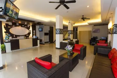 a lobby of a hotel with couches and red pillows at EX-IT Inn in Patong Beach