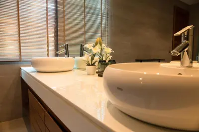 a bathroom with a white sink and flowers on a counter at Luxurious SeaView 4br Private Pool Villa by Intira Villas in Rawai Beach