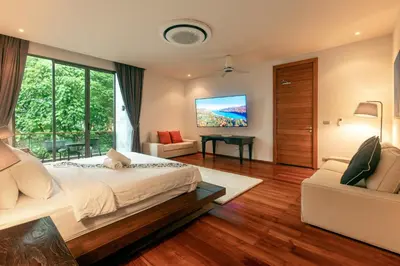 a bedroom with a large bed and a tv at Luxurious SeaView 4br Private Pool Villa by Intira Villas in Rawai Beach