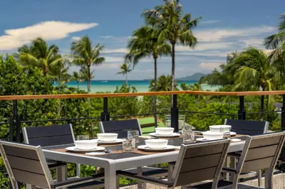 a table on a balcony with a view of the ocean at Luxurious SeaView 4br Private Pool Villa by Intira Villas in Rawai Beach