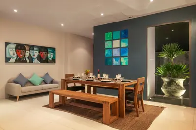 a dining room with a table and a couch at Luxurious SeaView 4br Private Pool Villa by Intira Villas in Rawai Beach