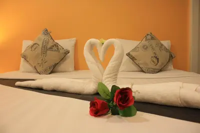 two swans made out of towels on a bed at Phuket Racha Kata Homestay in Kata Beach