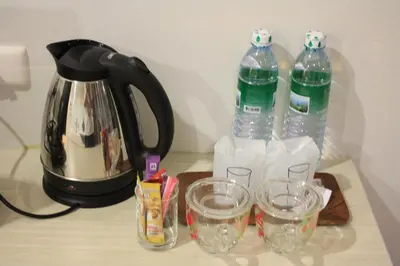 a tea kettle and two bottles of water on a table at Phuket Racha Kata Homestay in Kata Beach
