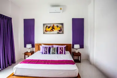 a bedroom with purple curtains and a large bed at Villa Bang Tao 3 Bedroom Q Kata Residence in Bang Tao Beach