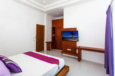a bedroom with a bed and a flat screen tv at Villa Bang Tao 3 Bedroom Q Kata Residence in Bang Tao Beach