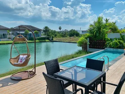 a patio with a table and chairs next to a pool at Villa Bang Tao 3 Bedroom Q Kata Residence in Bang Tao Beach