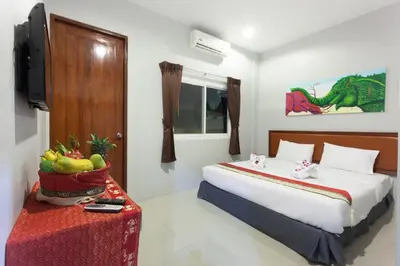 a hotel room with a bed and a television and a table at Freedom Hotel in Patong Beach