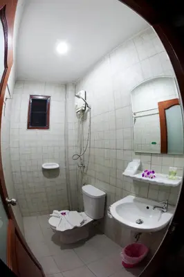 a bathroom with a toilet and a sink and a mirror at Freedom Hotel in Patong Beach