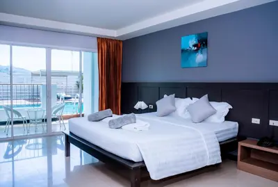 a bedroom with a large white bed and a balcony at Casa Del M Patong Phuket in Patong Beach